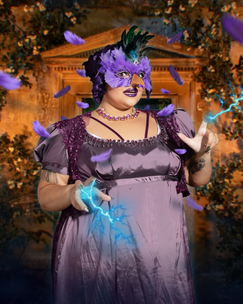 Mariana as the Duchess in a purple regency style dress, with a matching wig. In this image they also wear a bird mask, decorated with purple and green feathers, plus a beak. They have their hands posed like claws, and we've edited in blue electricity crackling off them. The background has been edited in to look like the candlelit walled garden of a stately home, and there are also more purple feathers flying about.