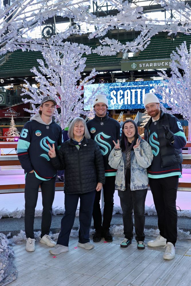 photo of Ray and their mom with 3 Kraken players. From left, Winterton, mom, Burakovsky, Ray, and Larsson. 