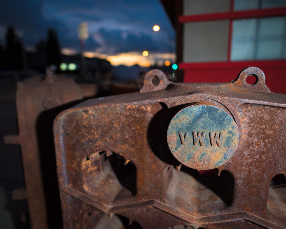 rusted piece of waterworks infrastructure on street corner in east vancouver with sunset in background