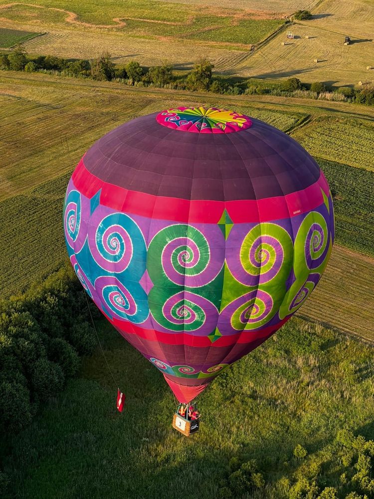Tiedyed hot air balloon over a field