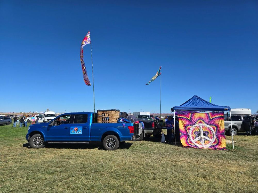Tailgate party after the flight, celebrating with champagne and breakfast, using the PeaceFlower tapestry for shade