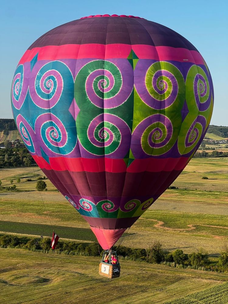 Tiedyed hot air balloon over a field