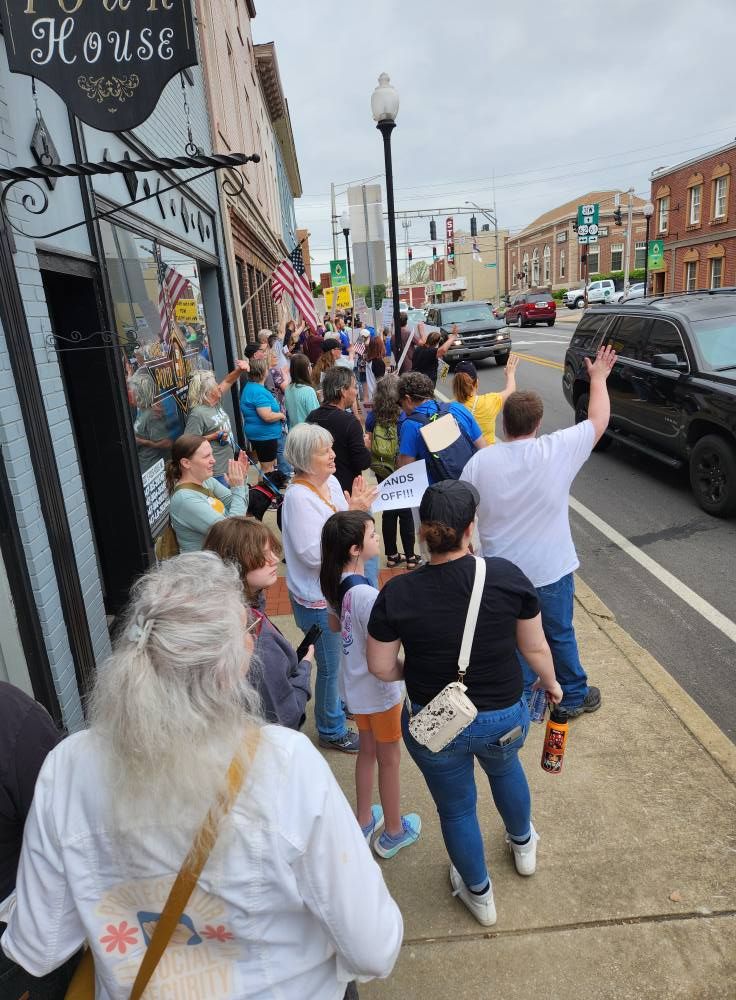 A crowd of people lining the street at a Hands Off demonstration in Elizabethtown, Kentucky. 