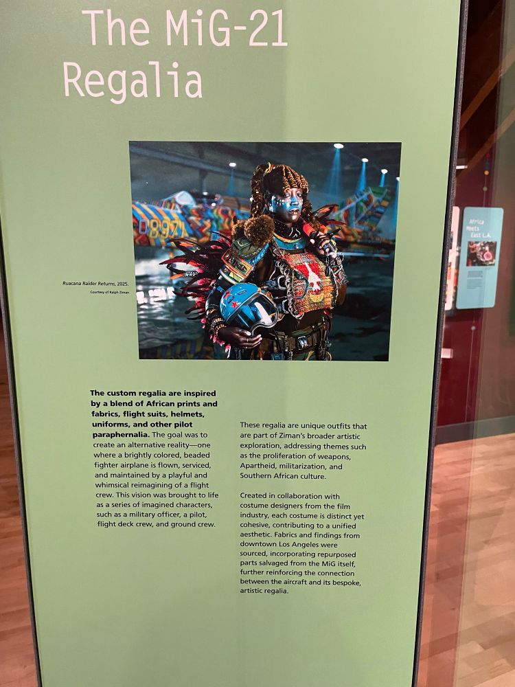 A sign with a synopsis of the reimagined flight suits for The MiG-21 Project.