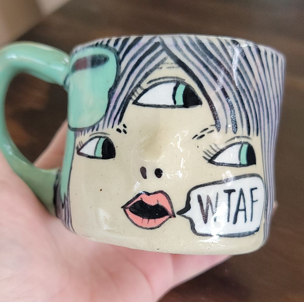 A mug featuring a lady with three eyes saying WTAF