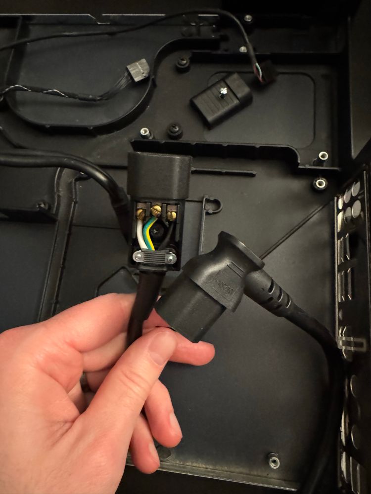 The receiver end of a C14 to C13 extension that was cut and reattached to an aftermarket connector. This was almost certainly done by hand because the strain relief isn’t fully engaged, and if they were built by machine it would be a fully molded part. 