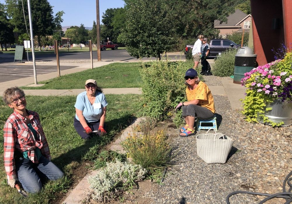 WSU Kittitas County Extension Master Gardener volunteers smile at the camera while working on a firewise demonstration garden.