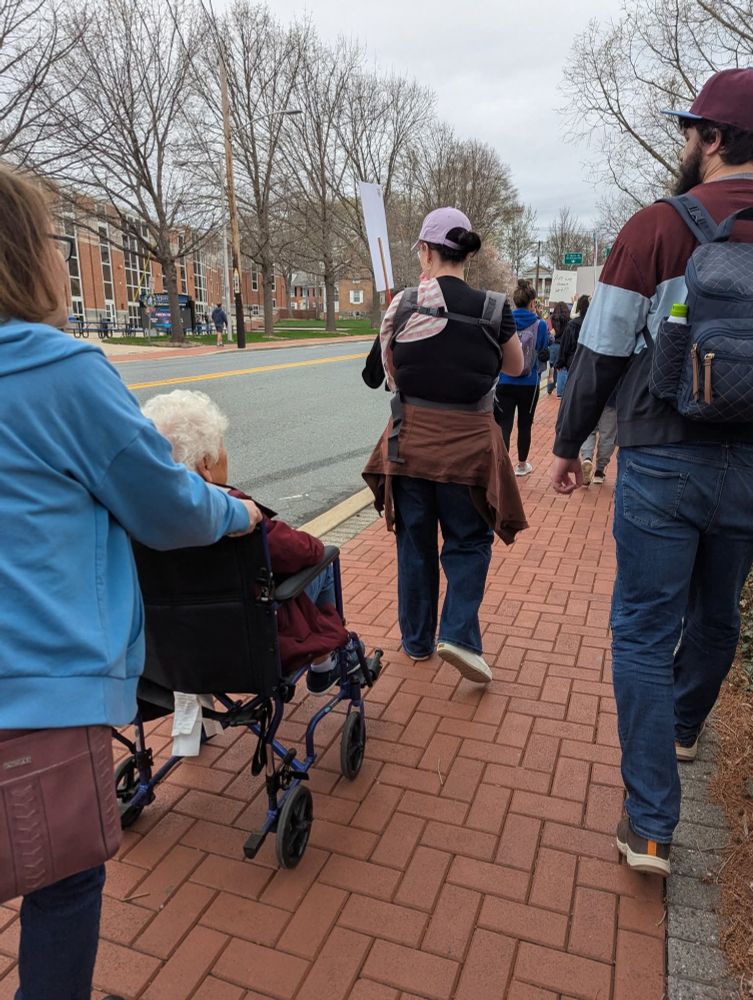 Woman carrying baby and woman being pushed in a wheelchair!