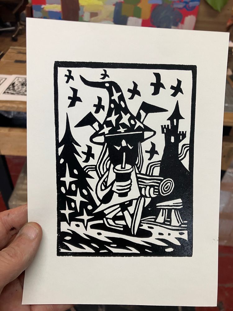 Lino block test print
Depicts a wizard holding a log whilst sipping on a drink in a cup with a straw. Birds are flying about and there’s a castle on a mountain along with a megalith 