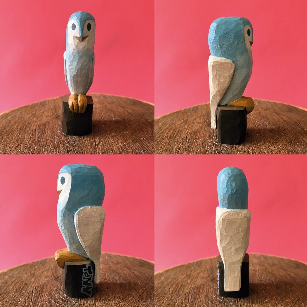 Wood carved and painted owl sat on a post
