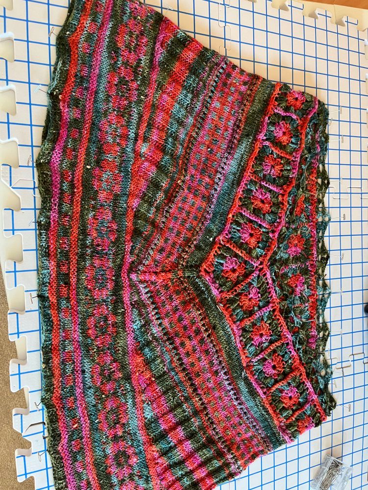 Ponchette with crocheted top and rows of color work in pink/orange and teal/forest