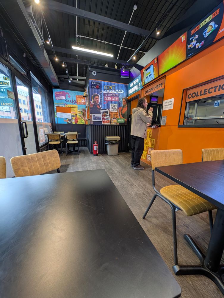 Giles.ordering vada pav at the counter.