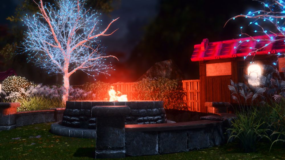 A large fire pit with stone benches and lit up trees