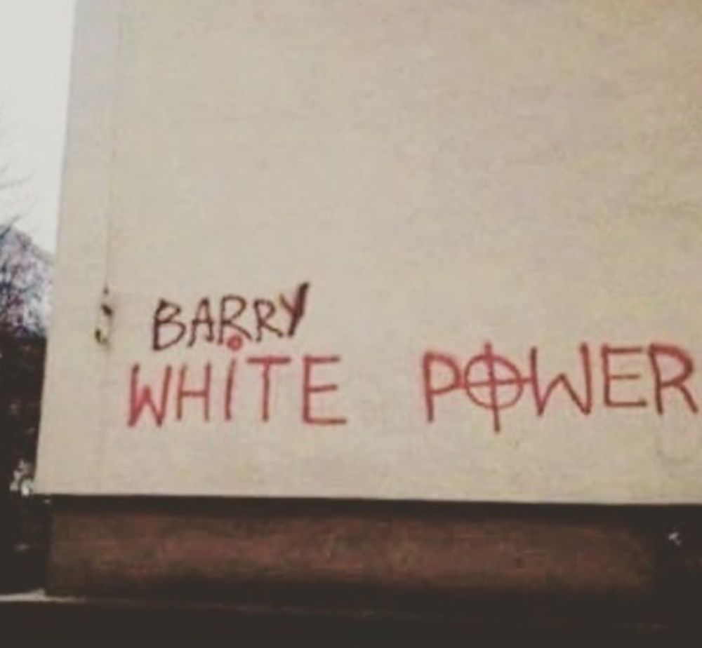 Ein Graffiti-Schriftzug an einer Wand: "White Power". Über dem Wort "White" wurde in einer leicht anderen Farbe das Wort "Barry" ergänzt.