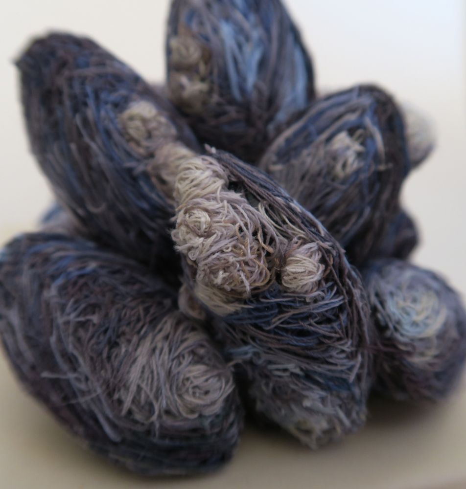 Close up photo of nine hand embroidered mussel shells clumped together 