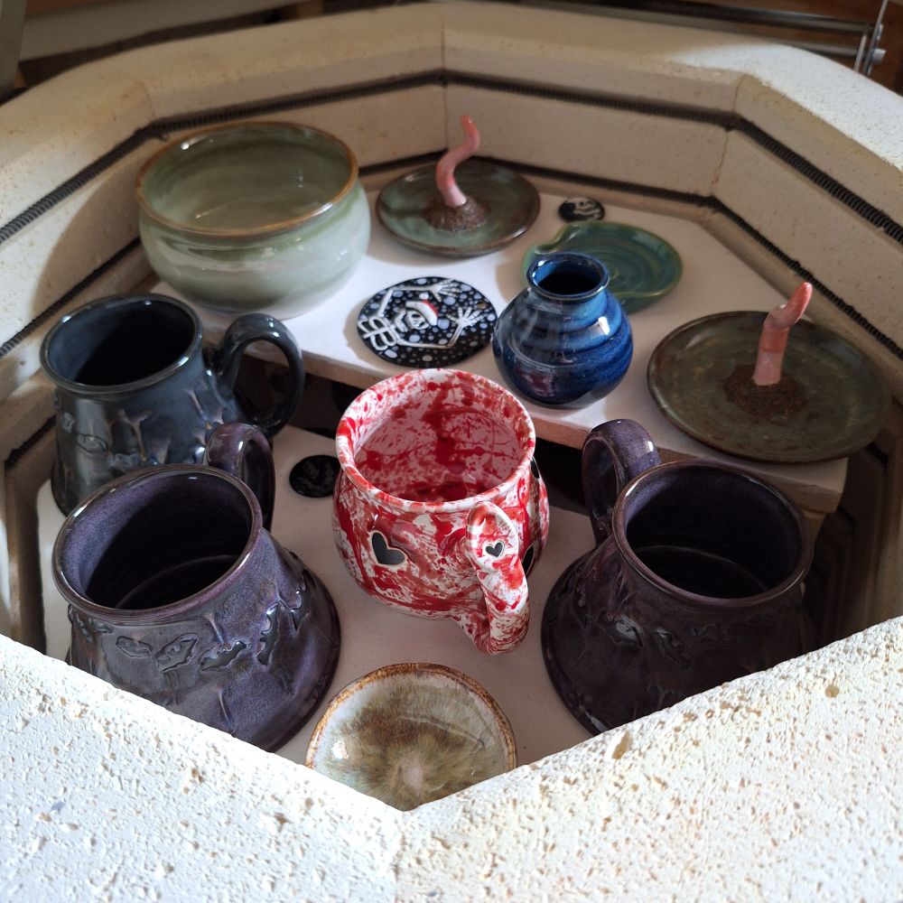 The top layer of my loaded kiln after everything has been fired. All the pieces have vibrant glazes ranging from reds, golds, greens, blues, and purples.