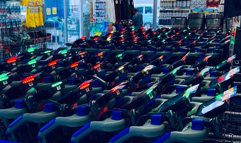 スーパーのレジカート置き場。各マシンの立ち上がりで、赤緑黄などの電光。