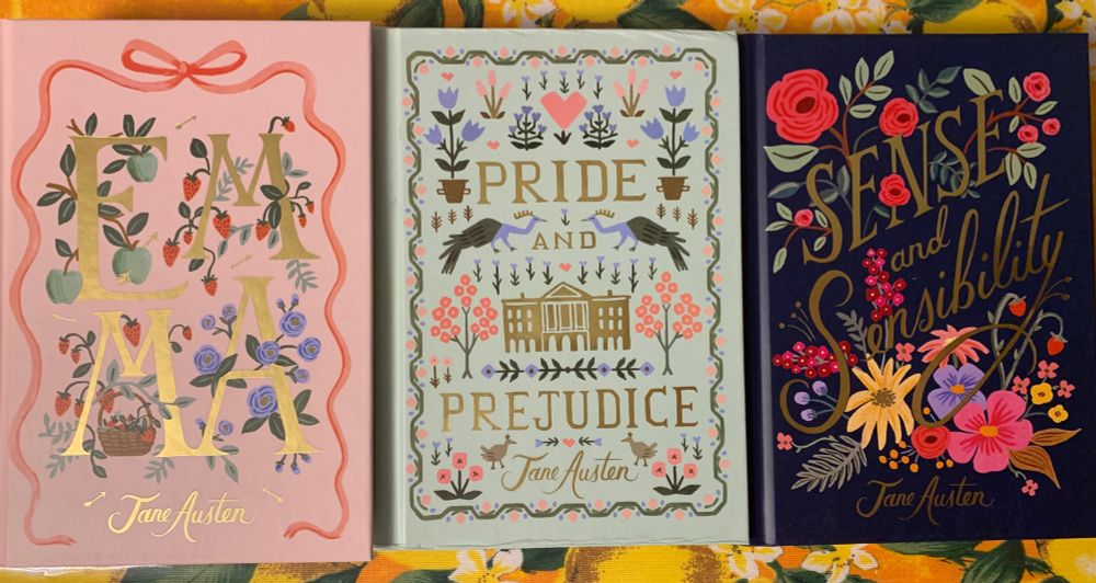 Das Bild zeigt die Cover der Bücher Emma (links), Pride und Prejudice (Mitte) und Sense and Sensibility (rechts).
Cover Emma ist rosa, jeder Buchstabe des Titels groß und Gold gedruckt. Das E mit grünen Äpfeln verziert, die beiden Ms mit Erdbeerranken, das A mit blassblauen Risen.
Cover Pride and Prejudice in Lindgrün mit abstraktem Tier- und Blumenmuster in rosa, blassblau und grün. Der Titel sowie ein kleines Herrenhaus in der Mitte sind Gold glänzend gedruckt.
Cover Sense and Sensibility in dunkelblau, der Titel ist in geschwungener Goldschrift aufgedruckt, darum herum zahlreiche Blumen in Rot- und Rosatönen sowie gelb und lila.
