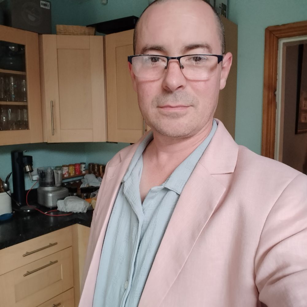 Me wearing a pink suit jacket and light blue Cuban shirt 