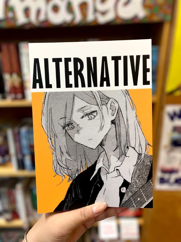 A hand holds up Alternative Self Liner Note in front of a blurred out background.