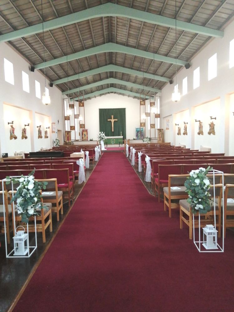 Interior of a modern church building decorated for a wedding with flowers and bows. 