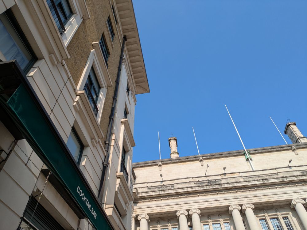 My view while drinking coffee in London near Westminster Bridge. Blue skies, the county hall, and an Italian cocktail bar in view