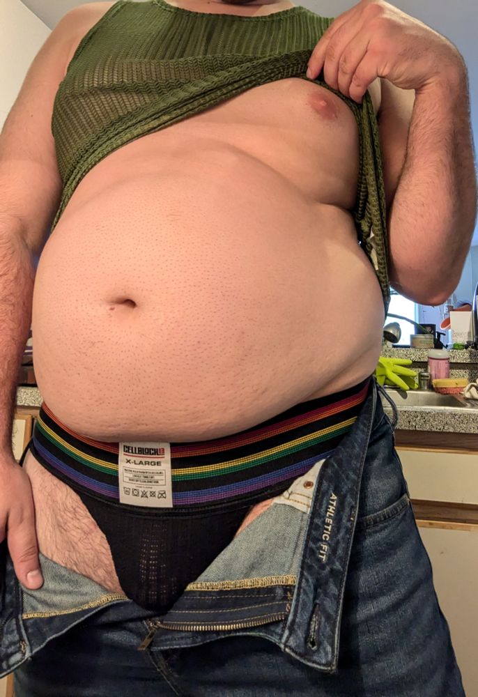Beefy man in a jock with a hairless chest 