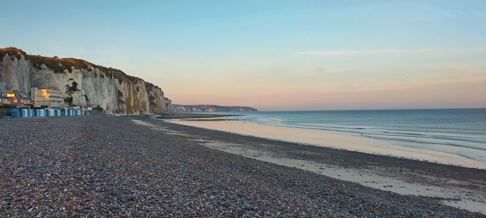 A shingle beach leading to white chalk cliffs