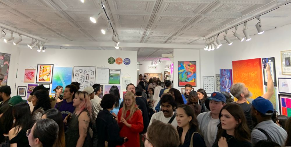 A crowded gallery of folks looking at cool typography art!