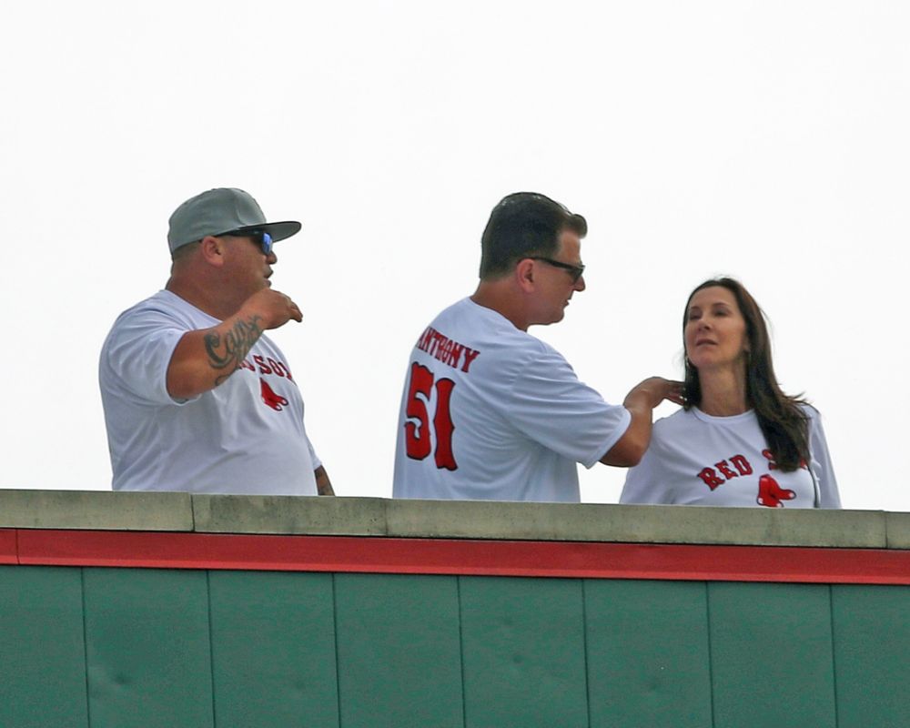 Members of Roman Anthony's family check out the Monster in an otherwise empty JetBlue Park to see him make his professional debut on August 9, 2022. They wear white Red Sox tees with Anthony 51 on the back.