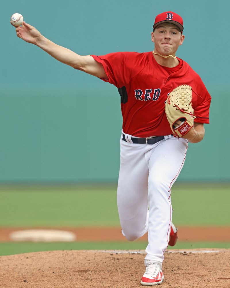 Right-handed pitcher Joey Gartrell is shown releasing the ball on a pitch at JetBlue Park in Fort Myers. He wears a red Red Sox jersey and white pants and has a tan glove on his left hand.