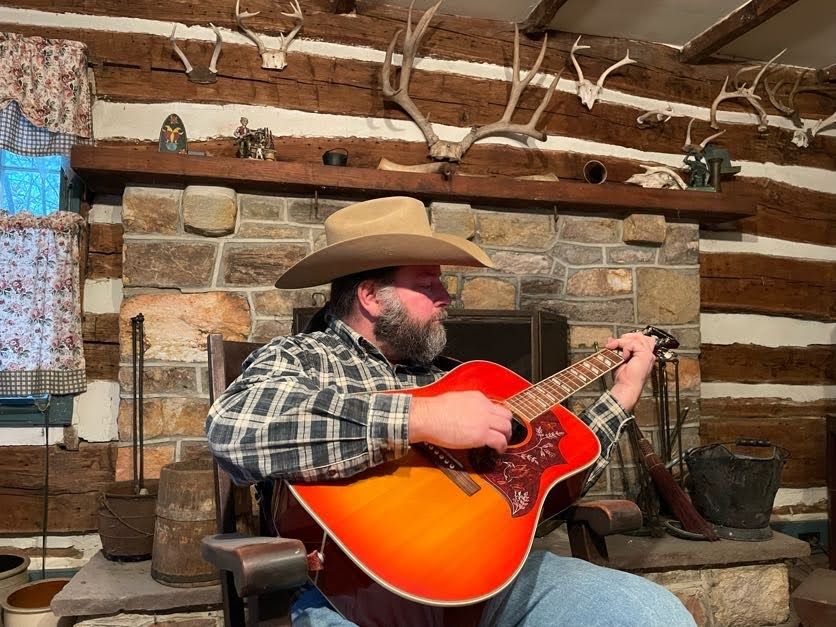 Mike Kuster playing guitar in his family's cabin on Catoctin Mountain in Maryland.