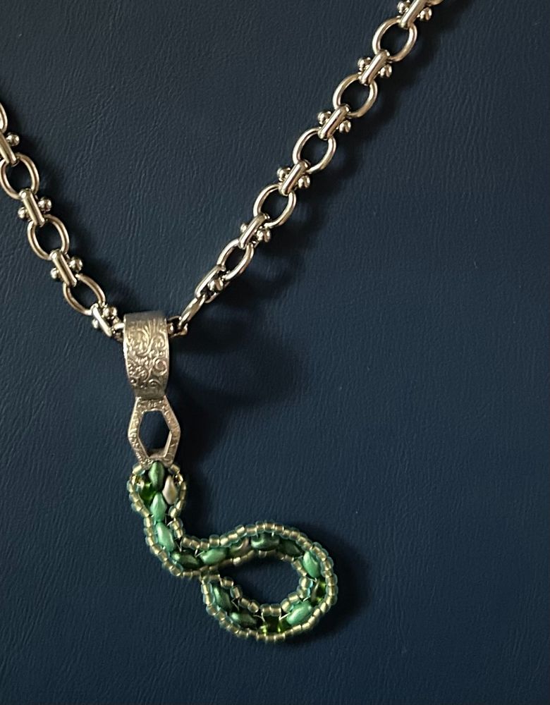 silver necklace with green beaded snake pendent