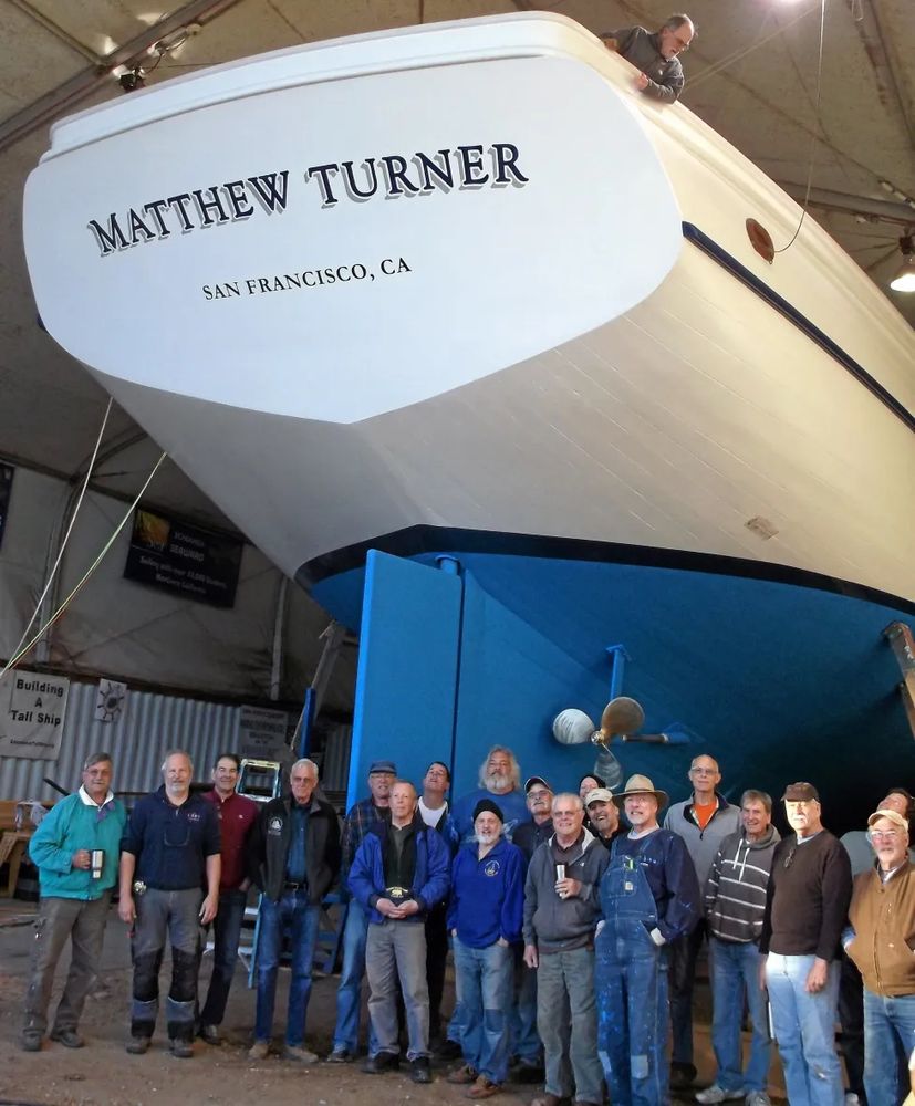 A photo of a group of people gathered at the stern of the brigantine Matthew Turner