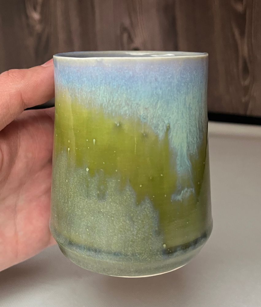 Front of cylindrical mug illustrating the interaction of the green and blue glazes. Handle is hidden at the rear. I hope to replicate this interaction/combination in the future. The glaze did run off the mug some and I will need to regulate my glaze layering, application thickness and unglazed area near the base for future projects.