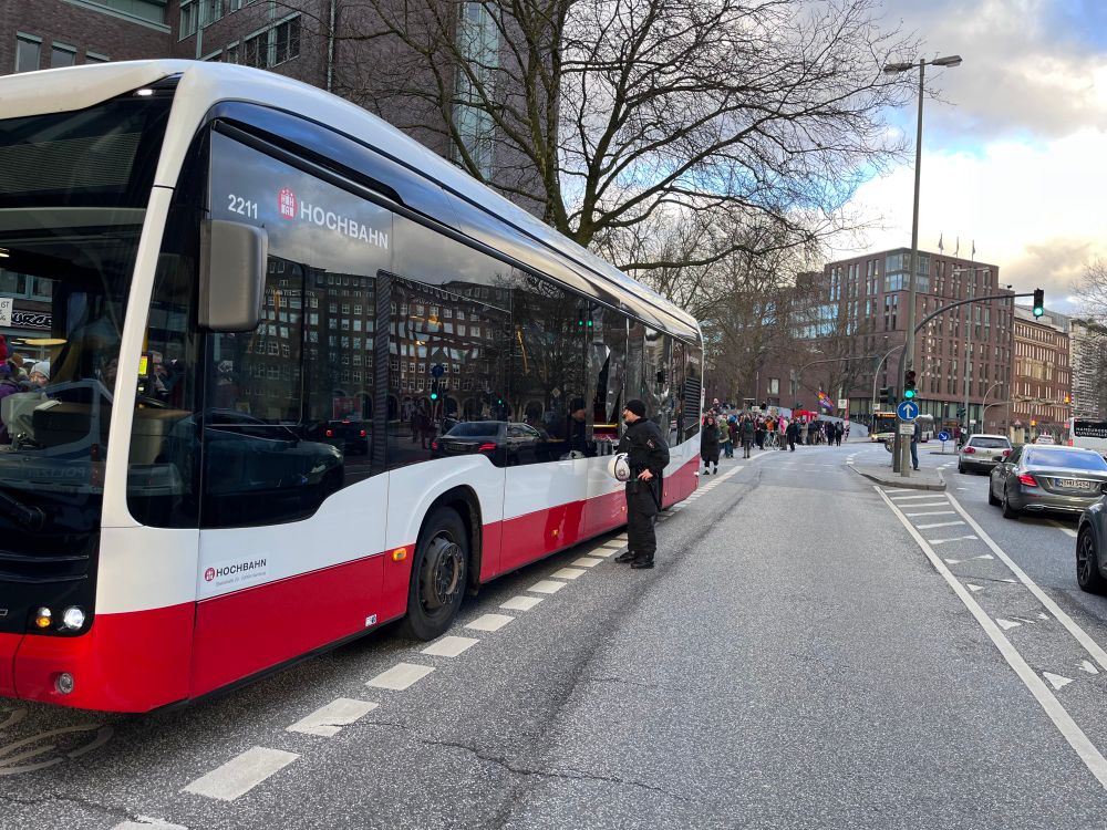 Ein HVV-Bus mit kaputter Scheibe im mittleren Bereich neben der Demo in Hamburg, 31.01.2025