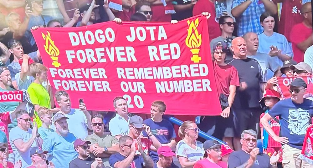 Photo of Liverpool crowd holding a banner up to remember Diogo Jota
