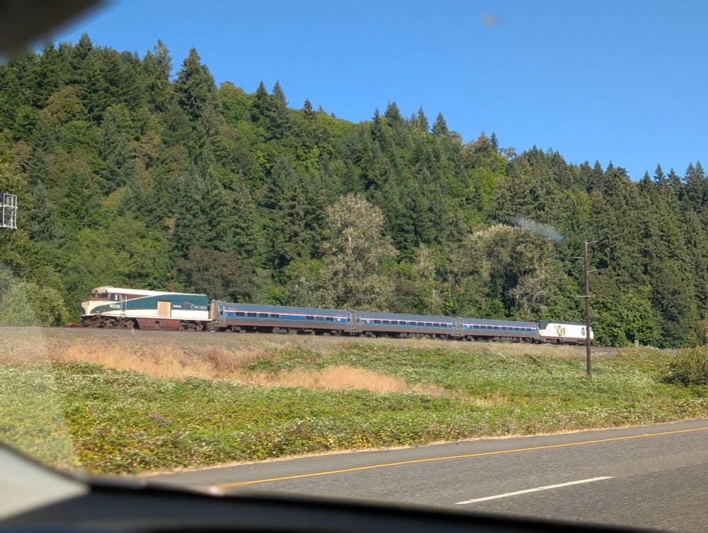 Amtrak train next to the freeway