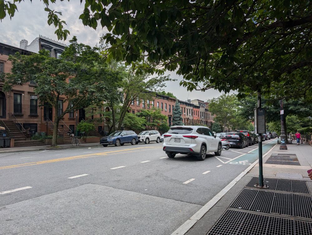 image of a street lined with brownstones and trees