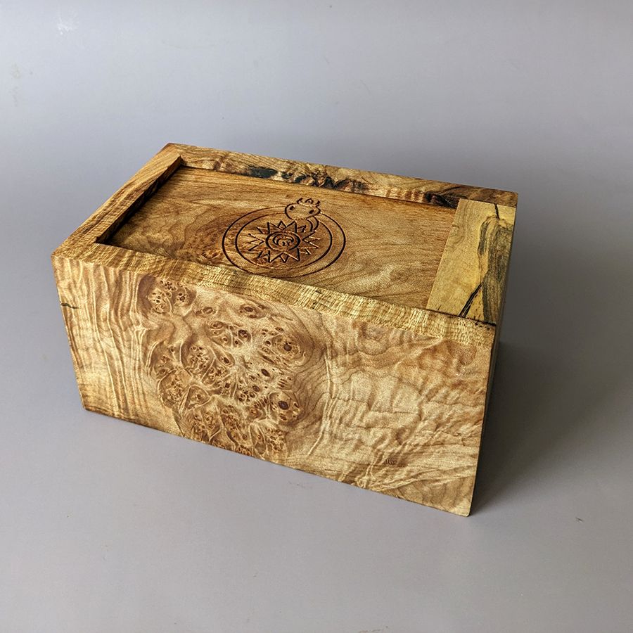 Heavily Figured Spalted Maple Burl Slide top box with a new engraving of a "daresay cute?" ouroboros crowned and encircling a sun moon and star