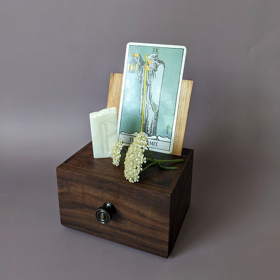 Mini Altar with the hermit card displayed as well as a yarrow offering and a alabaster charm with a misericorde engraved upon it.