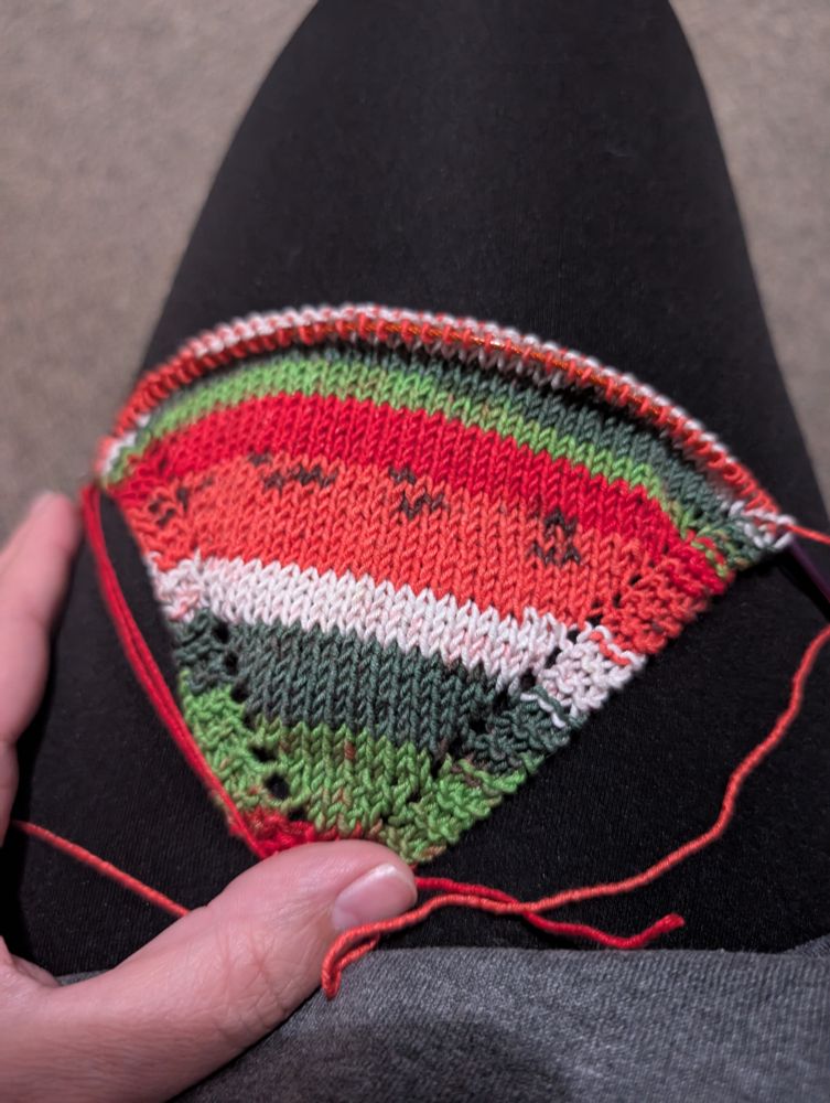 A bandana being knit in watermelon colors