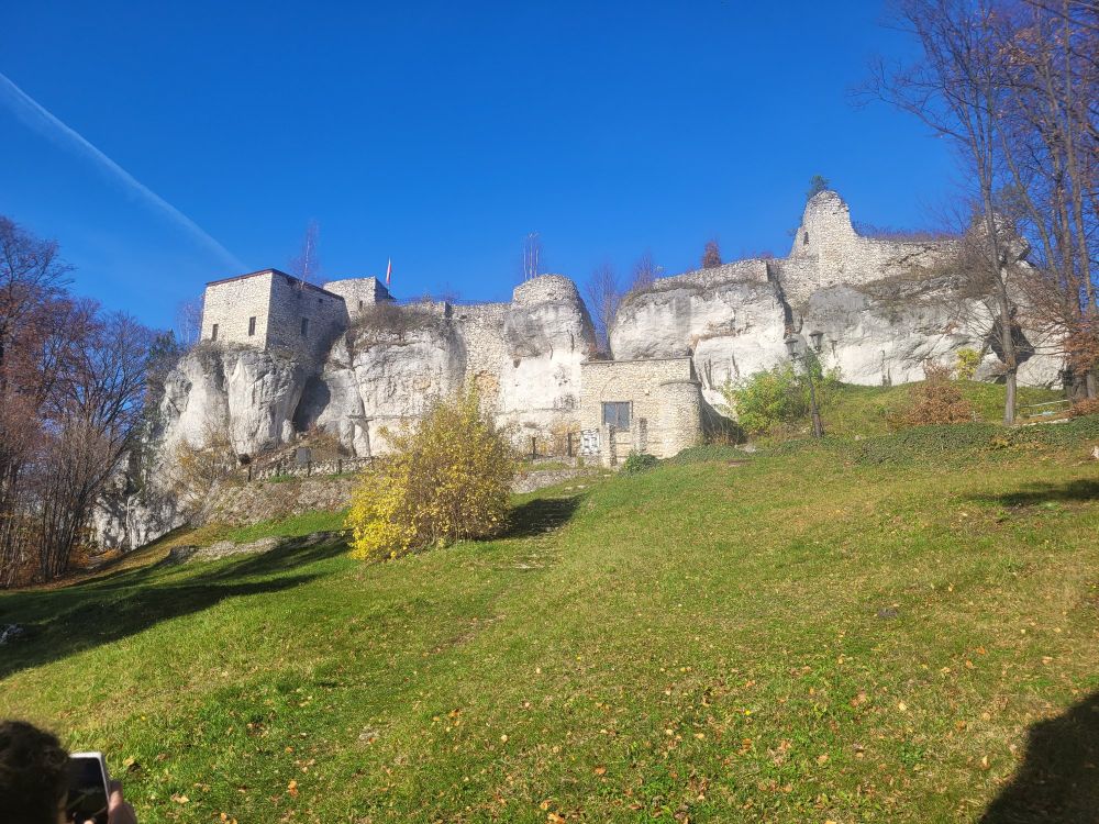 The ruins of a castle, partially carved into a rock structure, and partially built from stone