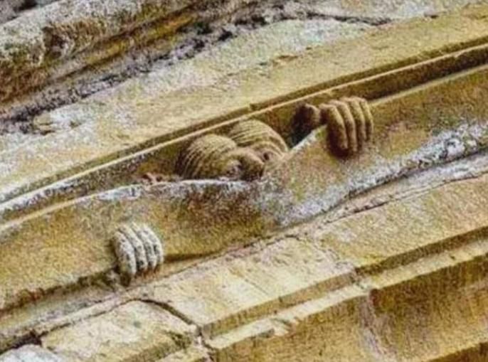 Un ange curieux de l'issue du jugement dernier, sculpté sur l'archivolte du tympan de l'abbaye de Conques 