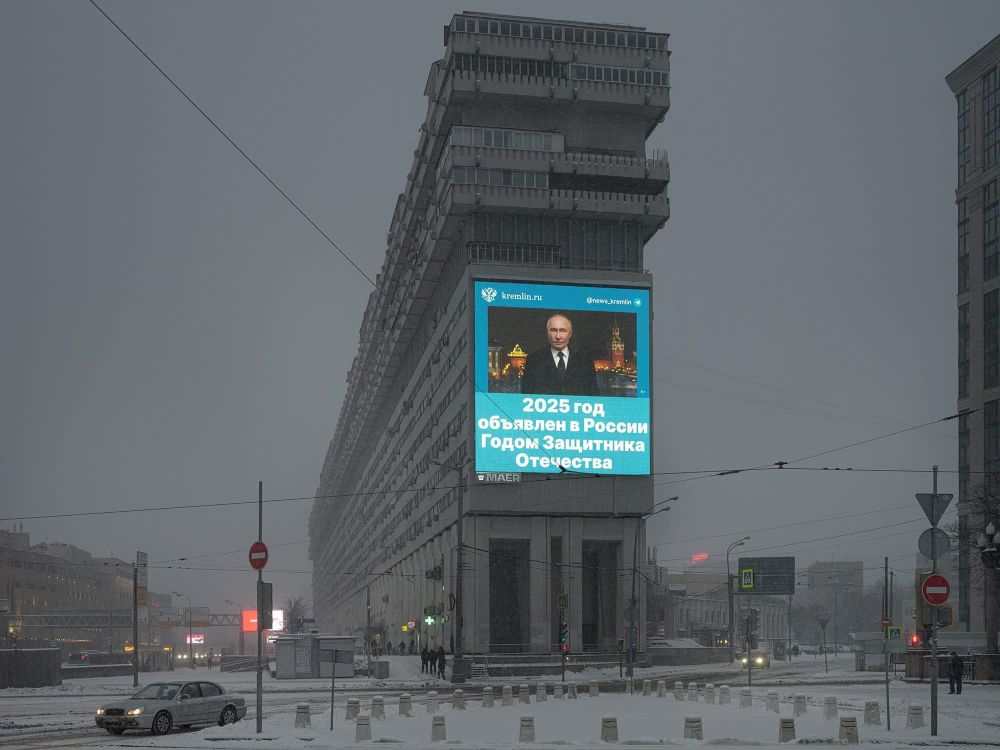 Ciel moscovite gris et sinistre 
Un immeuble brutaliste en béton
Sur l'immeuble, un écran géant avec Vladov qui annonce 2025 comme l'année de la "défense de la patrie"
Cette photo d'Alexander Gronsky score un joli 13/10 sur le glaucomètre