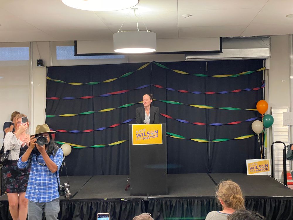 Katie Wilson stands at a podium 