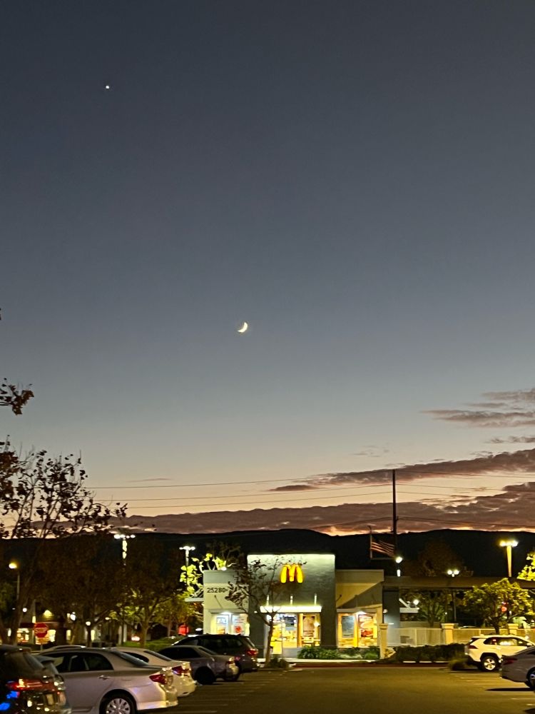 THE SOVEREIGN PLANET OF THE MOON AND VENUS SHINING LIGHT UPON A MCDONALDS IN NEAR PERFECT ALIGNMENT. 