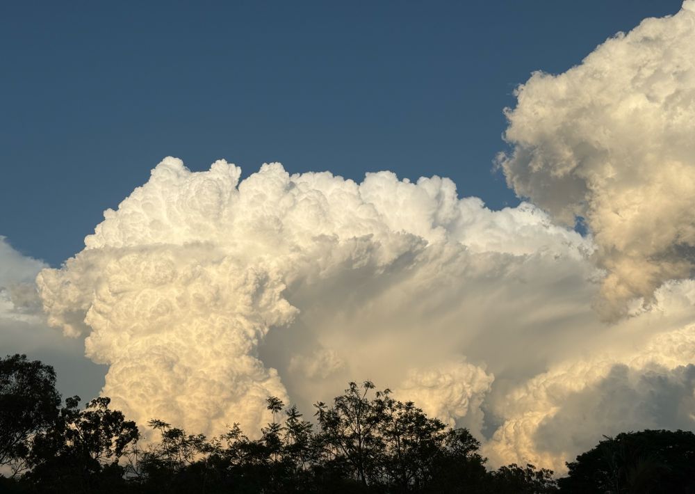 Towering frothy clouds tinged with hints of sunset.
