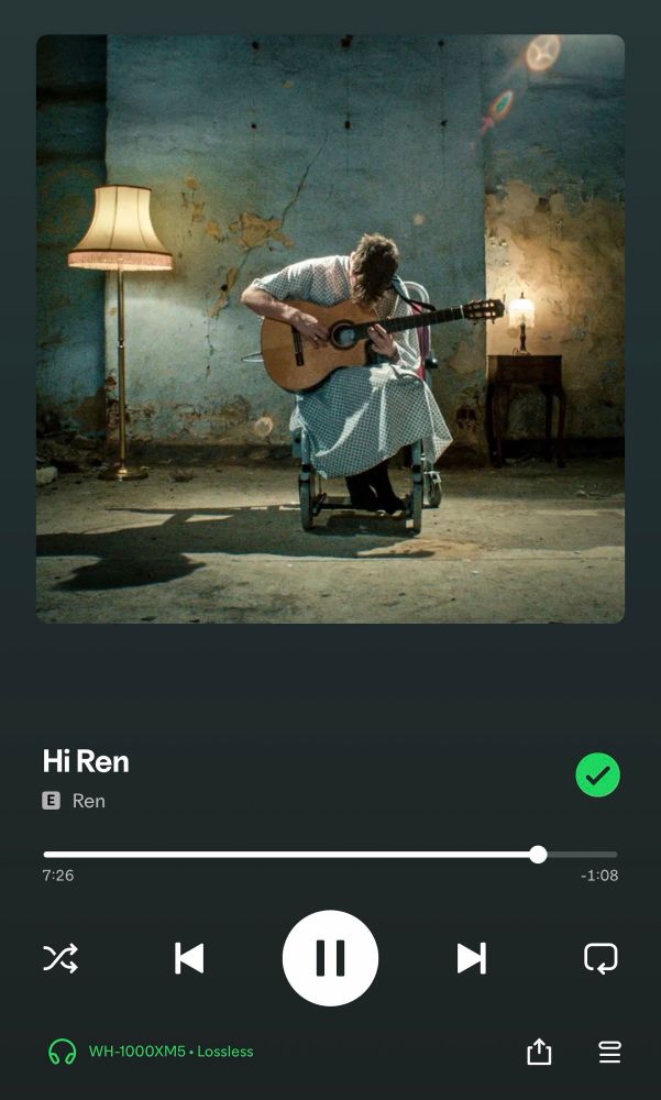Cover des Songs „Hi Ren“ des Künstlers „Ren“. Ein junger Mann sitzt in einem heruntergekommenen Raum in einem Rollstuhl und spielt Gitarre. Er trägt dabei ein Nachthemd und schaut nach unten auf seine Gitarre. 