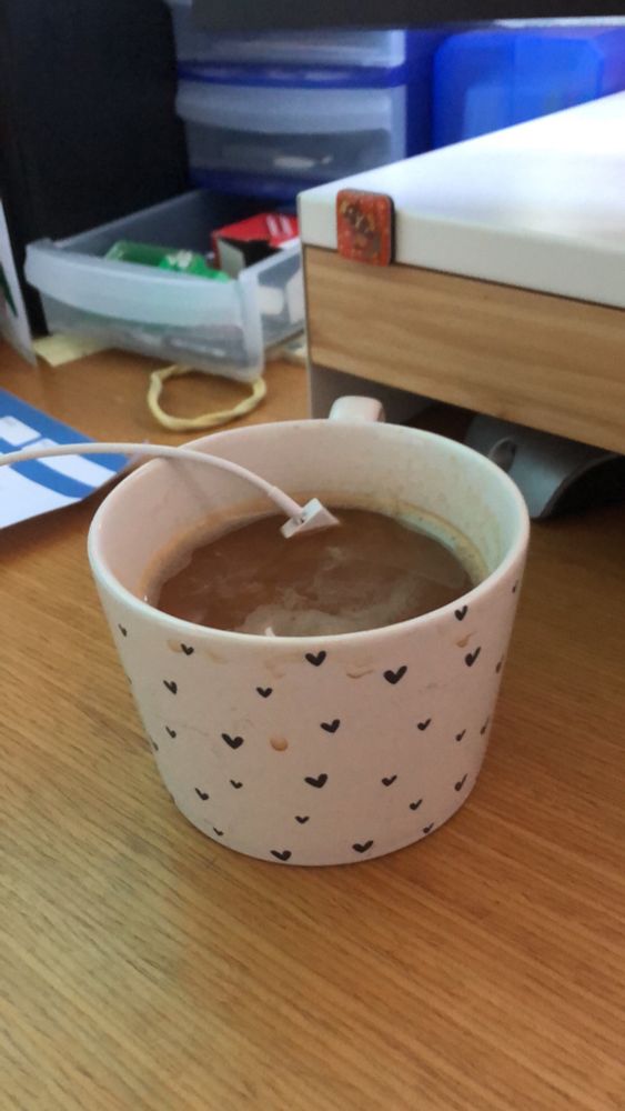 Kaffeehäferl, gefüllt mit Kaffee, ein USB-Kabel hängt im Inhalt.